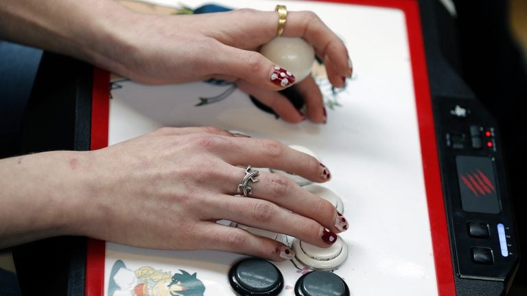 Hands playing an arcade game