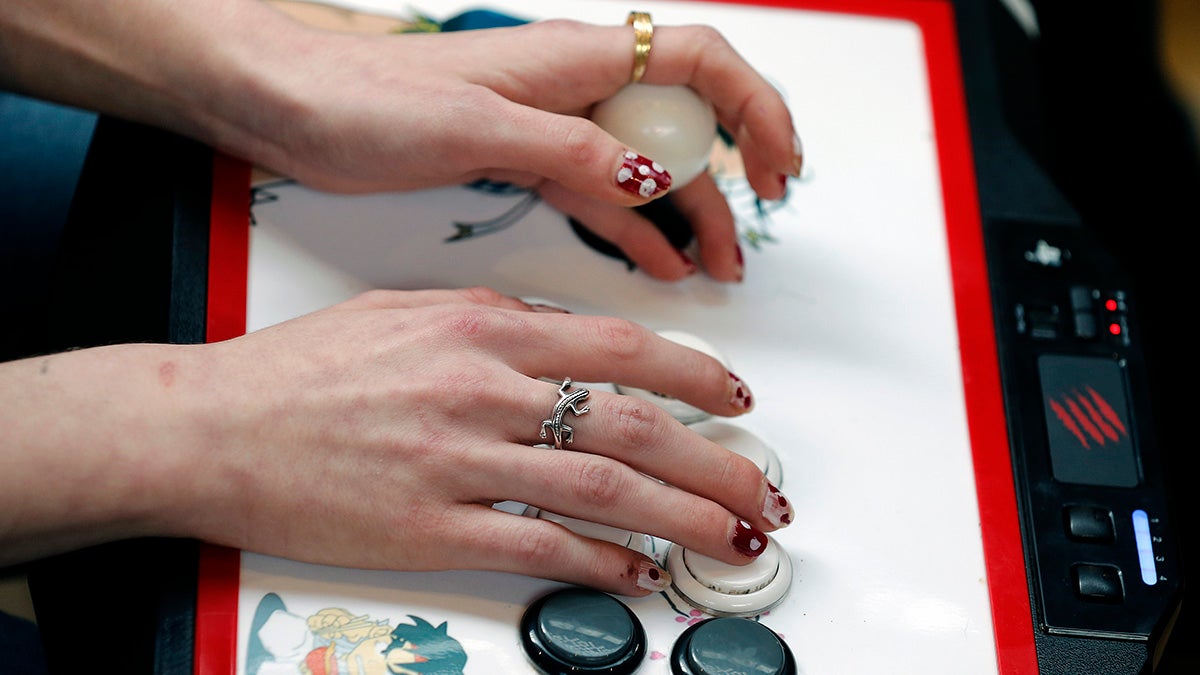 Hands playing an arcade game