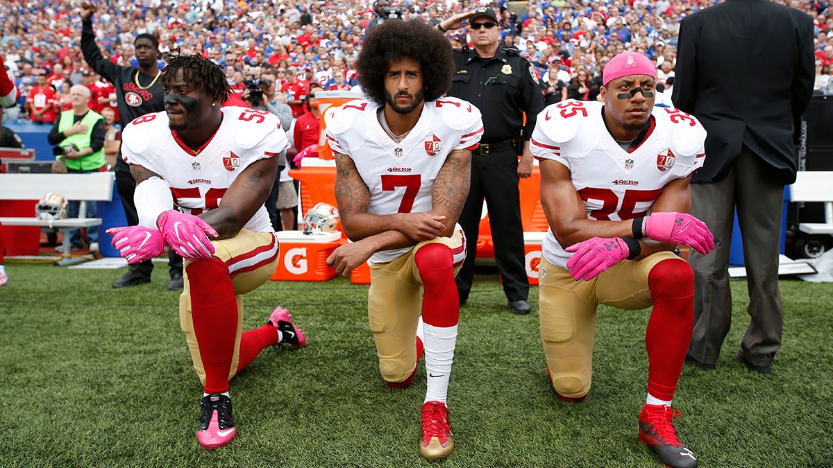 Colin Kaepernick and teammates Eli Herald and Eric Reid kneeling during the national anthem