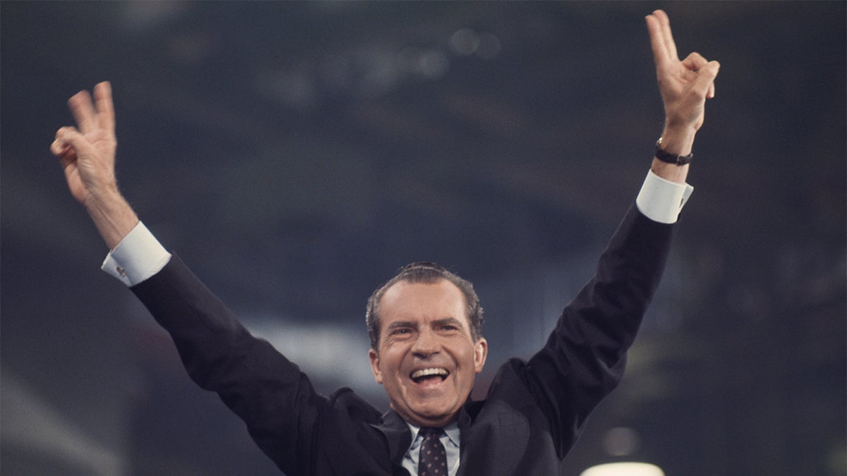 Former President Richard Nixon smiling and waving