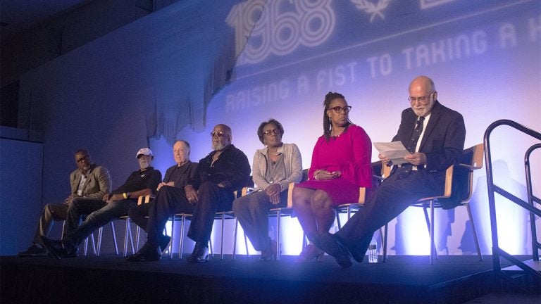 Kenneth Shropshire, John Carlos, Lance Wyman, Harry Edwards, Wyomia Tyus, Gina Hemphill-Strachan, and Paul Hoffman discuss the athlete protests at the 1968 Summer Olympics