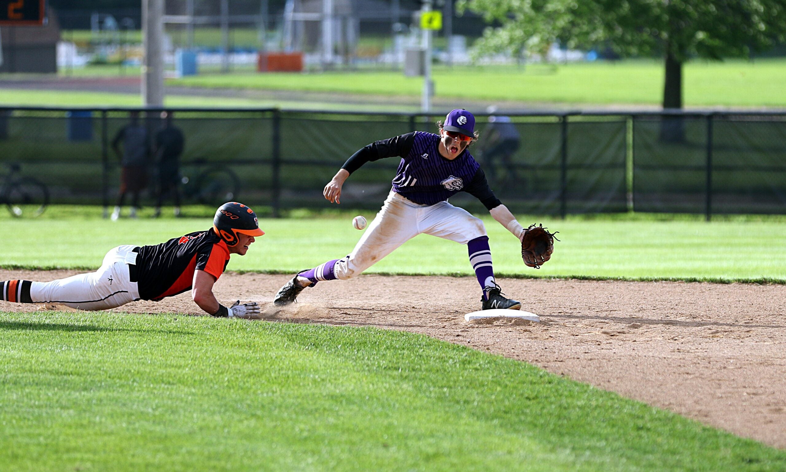 Baseball player diving to get back to second base. (Photo via Unsplash/Chris Chow)