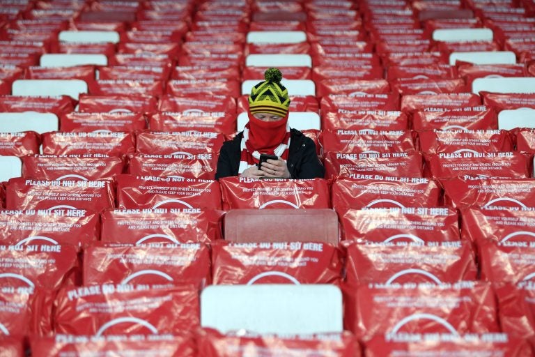 LONDON, ENGLAND - DECEMBER 03: A Arsenal FC fan is seen checking their phone as they sit in a socially distanced seat in the stands prior to the UEFA Europa League Group B stage match between Arsenal FC and Rapid Wien at Emirates Stadium on December 03, 2020 in London, England. A limited number of fans are welcomed back to stadiums to watch elite football across England. This was following easing of restrictions on spectators in tiers one and two areas only. (Photo by Mike Hewitt/Getty Images)